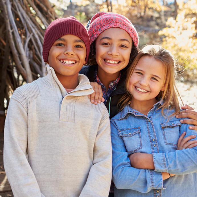 Three children smiling in Fall clothing